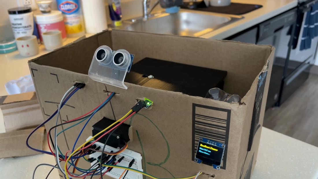 The built EcoSort bin: ultrasonic sensor, servo-driven sorting flap and a live OLED readout